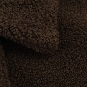 Macro detail of the dark brown fleece fabric showing dense curly sheepskin texture