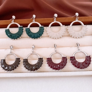 Detailed close-up of retro leather pendant earrings in four vintage colors on velvet