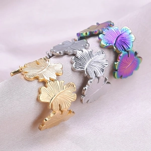 Detailed view of leaf-shaped stainless steel rings in gold, silver and rainbow finish