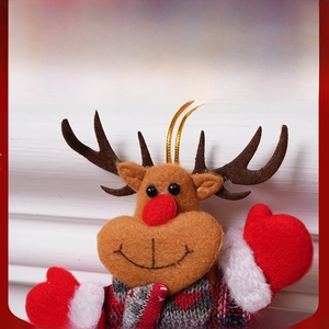 Close-up of a plush reindeer ornament featuring a red nose and knitted festive sweater