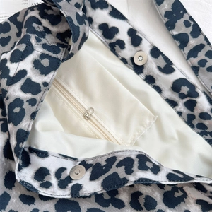 Detail of leopard print canvas bag showing internal zip pocket and magnetic buckle