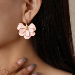 Elegant pink flower stud earrings with gold trim on a model for a sweet stylish look