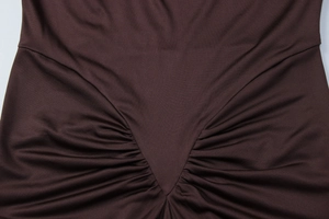 Macro view of the gathered V-shape pleats and fine knit texture on this brown dress