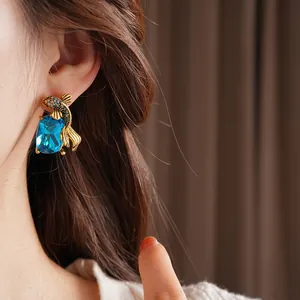 Vintage gold fish earrings with navy blue square gemstones and pavé zircon accents