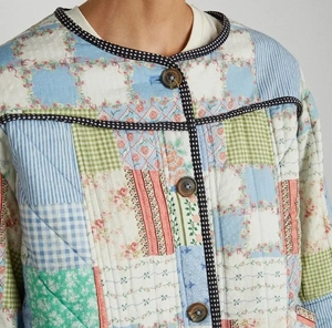 Close-up of colorful patchwork quilted cotton jacket with wooden buttons and stitching