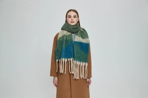 Detail of chunky knit scarf with long tassels in green, blue and beige color block