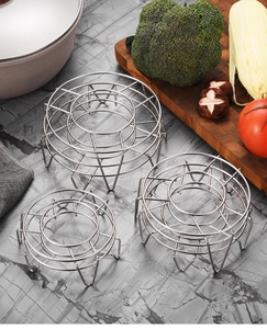 Trois tailles de supports à vapeur ronds en acier inoxydable dans un décor de cuisine moderne