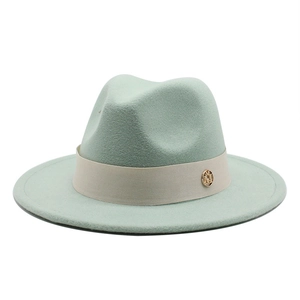 Detailed close-up of mint green wool felt fedora featuring a beige ribbon and gold logo