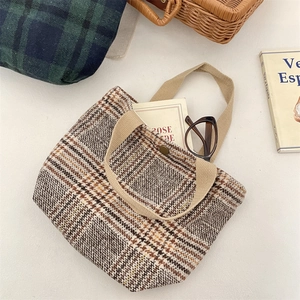 Dettaglio della borsa tote vintage in lana a quadri con trama spessa e chiusura magnetica