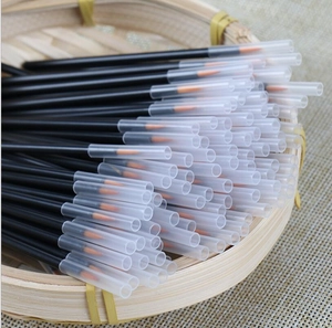 Detail view of disposable eyeliner brushes with orange tips and clear caps in a basket