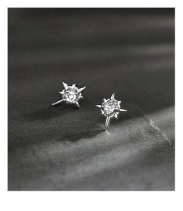 Macro shot of starburst stud earrings with sparkling round cubic zirconia in silver