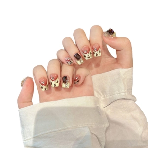 Faux ongles faits main à motif léopard avec paillettes dorées et pierres précieuses