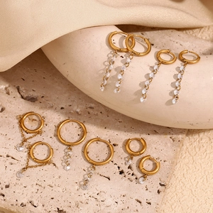 Detail of 18K gold plated stainless steel hoop earrings with white zircon tassel drops