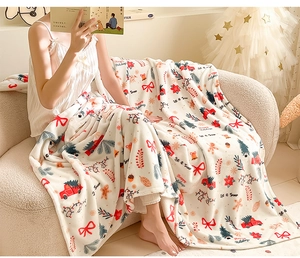 Cosy Christmas flannel blanket with festive prints shown in a warm home setting
