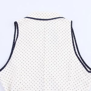 Détail du motif à pois sur la robe d'été sans manches avec une encolure soignée