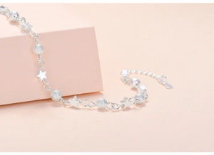 Close-up of S925 silver star bracelet with frosted beads on a pink geometric stand