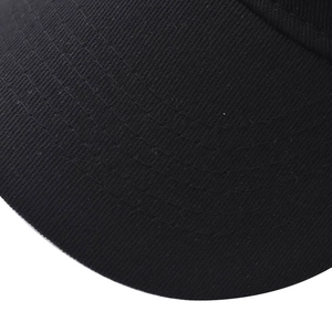 Gros plan sur la visière d'une casquette montrant les coutures et la texture du sergé
