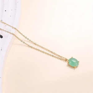 Detailed macro view of 18k gold chain featuring an oval green natural stone pendant