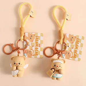 Cute Cream Bear cartoon keychains with angel and maid outfits on beige background