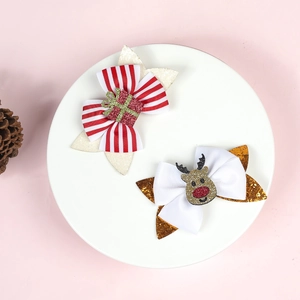 Detail of Christmas bow clips with glitter reindeer and gift box on pink backdrop
