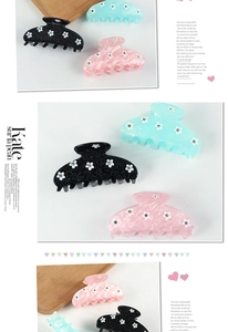 Détail de pinces à cheveux florales en noir, menthe et rose avec des strass brillants