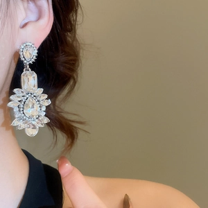 Close-up of sparkling silver drop tassel earrings with cubic zirconia on a model