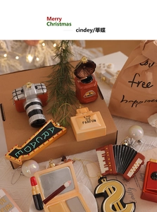 Dettaglio degli ornamenti natalizi creativi a forma di fotocamera retro e profumo