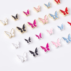 Macro detail of alloy butterfly nail charms with colorful enamel finish and gold edges