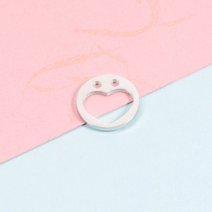 Polished 12mm stainless steel heart charm with smiley face cutout on pink and blue background