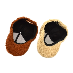 Detail view of teddy fabric baseball caps showing inner black lining and thick texture