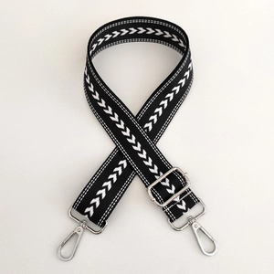 Macro shot of black and white herringbone nylon bag strap with silver metal swivel hooks