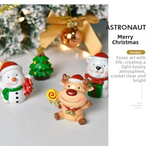Close-up of cute Christmas resin figurines featuring a deer and bear on a festive table