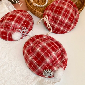 Detail of red plaid Christmas hair clip with snowflake brooch and white fur pompom décor