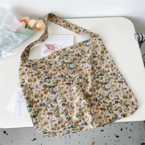 Detail of corduroy tote bag with small floral patterns on a minimalist white desk