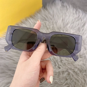 Detail of transparent purple rectangle sunglasses frame held against a yellow background