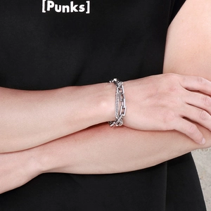 Close-up of double-layer silver Cuban link chain bracelet worn on wrist with punk style