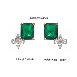 Detailed macro view of emerald green stone earrings with white cubic zirconia floral accents