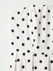 Détail du tissu à pois blancs avec tissage sergé et conception à plis de la robe