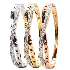 Detailed view of crisscross bangles in gold, silver and rose gold with Roman numerals
