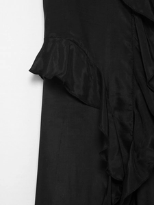 Detailed macro view of black ruffle trim and pleated fabric on a sleeveless V-neck maxi dress