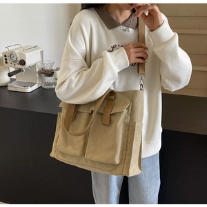 Detailed view of beige canvas tote bag with multi-pockets and functional dual handles