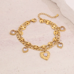 Goldenes zweilagiges Armband mit Kaffeebohnenkette und Herz-Zirkonia-Anhängern auf Stein