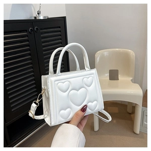 Détail du sac bandoulière blanc en cuir PU avec motifs de cœurs en relief et poignée
