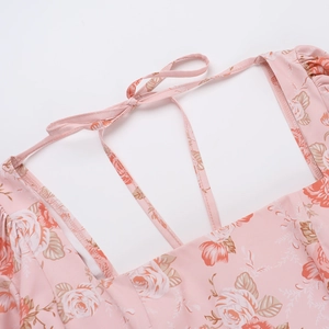 Détail de l'encolure carrée avec imprimé rose et nœud au dos d'une robe à fleurs rose