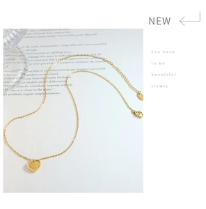 Macro detail of 18K gold plated heart pendant necklace with K18 engraving and lobster clasp