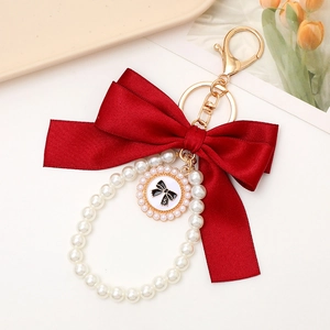 Elegant red bow and pearl wristlet keychain with a gold number 5 pendant for bags