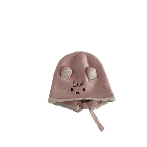 Pink knitted baby winter hat with cute bunny ears, embroidery, and chin straps