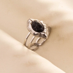 Detailed macro view of retro silver ring with oval black stone on soft knit fabric