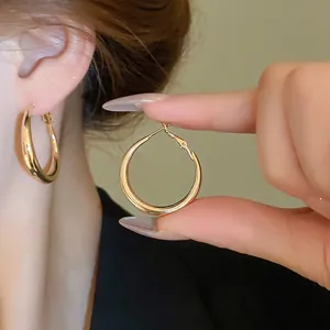 Minimalist high-polish chunky gold hoop earrings for women with mirror finish design