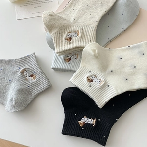 Flat lay of cotton socks with puppy embroidery and polka dot patterns in multiple colors